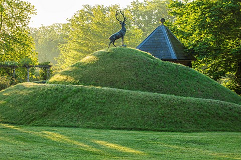 HAZELBY_HOUSE_BERKSHIRE_GRASS_TURF_MOUND_WITH_STAG_STATUE_SCULPTURE_ON_TOP_SUMMER_LAWN