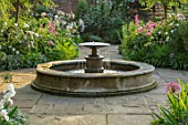 MORTON HALL, WORCESTERSHIRE: SOUTH GARDEN,  SUMMER. CIRCULAR FOUNTAIN, WALL, ROSE - ROSA OLD BLUSH CHINA. EVENING LIGHT, FORMAL, COUNTRY, GARDEN, ENGLISH, CLASSIC, WATER, FEATURE