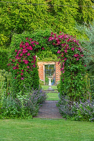 COTTAGE_ROW_DORSET_ARCH_WITH_CLEMATIS_MADAME_JULIA_CORREVON_SUNDIAL_AND_WALL_FRAMED_VIEW_BRIGHT_PINK