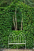 THE OLD RECTORY, QUINTON, NORTHAMPTONSHIRE: DESIGNER ANOUSHKA FEILER: WHITE METAL SEAT, BENCH AND ARCH CUT IN BEECH HEDGE. HEDGING, HEDGES, CLIPPED