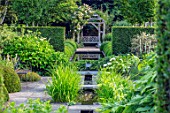 WOLLERTON OLD HALL, SHROPSHIRE: RILL, CANAL, WOODEN PERGOLA, ARBOUR, BENCH, SEAT, POOL, RECTANGULAR, WATER, HEDGES, HEDGING, SUMMER, REFLECTIONS, AXIS, SYMMETRY, FOCAL, POINT