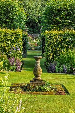 WOLLERTON_OLD_HALL_SHROPSHIRE_VIEW_THROUGH_SUNDIAL_GARDEN_IN_SUMMER_HEDGES_HEDGING_LAWN_GRASS_PATH_V