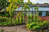 MORTON HALL, WORCESTERSHIRE: THE KITCHEN GARDEN, JULY. ARBOUR, ARCH, ARCHWAY, COVERED IN SWEET PEAS. CLIMBING, CLIMBERS, SUMMER, POTAGER, VEGETABLE, GREENHOUSE