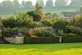 BOURTON HOUSE GARDEN, GLOUCESTERSHIRE: LAWN, WALL, HEDGES, RAISED, BED, PENSTEMONS, BORDER, HERBACEOUS, FORMAL, GREEN, AUTUMN, FALL, SEPTEMBER, CLASSIC, ENGLISH