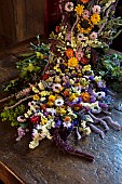 BADDESLEY CLINTON, WARWICKSHIRE: THE NATIONAL TRUST- CHRISTMAS, 15TH AND 16TH CENTURY MOATED MANOR HOUSE. GREAT HALL, DRIED FLOWER ARRANGEMENT, HELICHRYSUM, LARKSPUR