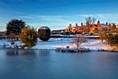 FELLEY PRIORY, NOTTINGHAMSHIRE: WINTER - SNOW. VIEW OF THE PRIORY FROM THE LAKE IN DECEMBER. ENGLISH, COUNTRY, GARDEN, POOL, POND, WATER, SUNRISE, DAWN, FROZEN