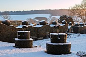 FELLEY PRIORY, NOTTINGHAMSHIRE: WINTER - SNOW. CLIPPED, TOPIARY, HEDGES, HEDGING, YEW CASTLES, FLAGS, DECEMBER, TAXUS, DAWN, SUNRISE, BOX