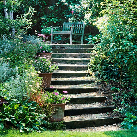 STEPS_EDGED_WITH_RAILWAY_SLEEPERS_LEAD_UP_TO_SECLUDED_WOODEN_SEAT__DESIGNER_LUCY_GENT