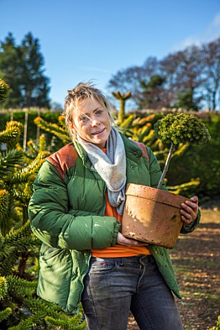 LIME_CROSS_NURSERY_EAST_SUSSEX_WINTER_JANUARY_OWNER_HELEN_TATE_CARRYING_TERRACOTTA_CONTAINERS_OF_CON