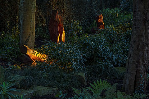 MORTON_HALL_GARDENS_WORCESTERSHIRE_WOOD_SCULPTURE_FROM_FELLED_WELLINGTONIA_IN_THE_ROCKERY_EVENING_LI