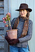 HERTFORDSHIRE HELLEBORES, LORNA JONES HOLDING A TERRACOTTA CONTAINER OF HELLEBORES