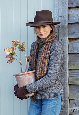 HERTFORDSHIRE_HELLEBORES_LORNA_JONES_HOLDING_A_TERRACOTTA_CONTAINER_OF_HELLEBORES