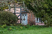 OLD COUNTRY FARM, WORCESTERSHIRE: VIEW TO FRONT DOOR OF HOUSE, COTTAGE WITH GREY DOOR AND HELLEBORE WREATH. MARCH, ENGLISH, COUNTRY