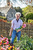 THE OLD PARSONAGE, DORSET: OWNER CHARLIE MCCORMICK PICKING TULIPS IN THE CUTTING GARDEN