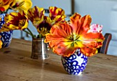 THE OLD PARSONAGE, DORSET: KITCHEN TABLE WITH TULIPS PICKED FROM THE GARDEN IN VASES. ORANGE, STRIPED, YELLOW, COLOURFUL, FLOWER, INTERIOR, HOME, ORNAMENTAL,DECORATIVE.