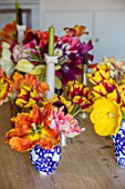 THE OLD PARSONAGE, DORSET: KITCHEN TABLE WITH TULIPS PICKED FROM THE GARDEN IN VASES. ORANGE, STRIPED, YELLOW, COLOURFUL, FLOWER, INTERIOR, HOME, ORNAMENTAL,DECORATIVE.CANDLES.