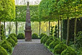 MITTON MANOR, STAFFORDSHIRE: PATH, CLIPPED TOPIARY BOX, BUXUS, HORNBEAM, HEDGES, HEDGING, SPRING, SYMMETRY, FORMAL, ENGLISH, COUNTRY GARDEN, EVERGREEN, GREEN, CHAIRS, OBELISK