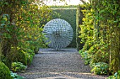 MITTON MANOR, STAFFORDSHIRE: PATH, TOPIARY, AVENUE, FORMAL, COUNTRY, BOX, TOPIARY, HEDGES, HEDGING, EVERGREEN, SPRING, STEEL, ALLIUM, SPHERE, SCULPTURE BY RUTH MOILLIET