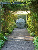 MITTON MANOR, STAFFORDSHIRE: PATH, TOPIARY, AVENUE, FORMAL, COUNTRY, BOX, TOPIARY, HEDGES, HEDGING, EVERGREEN, SPRING, OBELISK, STEEL, ALLIUM, SPHERE, SCULPTURE BY RUTH MOILLIET