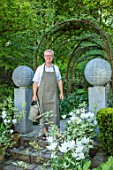 CLAUS DALBY GARDEN, DENMARK: CLAUS DALBY WATERING CONTAINERS IN THE SUNKEN GARDEN, SPRING. STEPS, TERRACOTTA CONTAINERS WITH TULIPS - TULIPA WGITE TRIUMPHATOR, PATIO, TERRACE