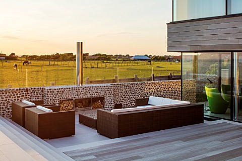 SEASIDE_GARDEN_DESIGNED_BY_ANTHONY_PAUL_MODERN_HOUSE_DECKING_LOUNGE_SEATS_FIREPLACE_CHIMNEY_COUNTRYS