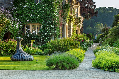 ASTHALL_MANOR_OXFORDSHIRE_SCULPTURE_THE_SINGER_OF_TALES_BY_JOHN_ISHERWOOD_LAWN_PATH_WITH_ALCHEMILLA_