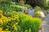 SOUTH HAYES, OXFORD: DESIGNER SARAH NAYBOUR: GARDEN ON A SLOPE - GRAVEL PATHS, ACHILLEA MOONSHINE, STIPA TENUISSIMA. SLOPING, SLOPES, WOODEN BENCHES, SEATS, OAK SLEEPERS