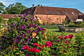 THE WALLED GARDEN AT COWDRAY, WEST SUSSEX: CLEMATIS AND RED ROSE WITH FOUNTAIN AND LAWN.