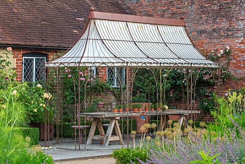 THE_WALLED_GARDEN_AT_COWDRAY_WEST_SUSSEX_OUTDOOR_DINING_SEATING_AREA_WITH_RUSTY_METAL_PERGOLA_AWNING