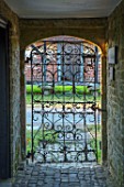 THE WALLED GARDEN AT COWDRAY, WEST SUSSEX: VIEW OUT OF ORNATE METAL ENTRANCE GATE TO GARDENS. ENGLISH, COUNTRY, GARDEN