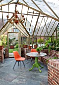 THE WALLED GARDEN AT COWDRAY, WEST SUSSEX: ENGLISH, COUNTRY, GARDEN, INSIDE OF GREENHOUSE, ORANGE CHAIR, TABLE, GLASSHOUSE