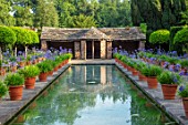 HAMPTON COURT CASTLE, HEREFORDSHIRE:THE DUTCH GARDEN, JULY - BLUE AGAPANTHUS IN TERRACOTTA CONTAINERS , RECTANGULAR FORMAL POOL, CANAL, BUILDING, GARDEN, ENGLISH, WATER