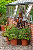 MORTON HALL GARDENS, WORCESTERSHIRE: KITCHEN GARDEN, JULY, TERRACOTTA CONTAINERS PLANTED WITH CANNAS AND DAHLIA NEW BABY