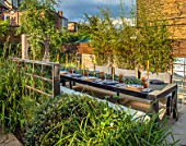 TANYA SOUTHWORTH GARDEN, LONDON, DESIGNER ANOUSHKA FEILER: TABLE, BENCHES, CANDLES, BAMBOOS IN CONTAINERS, MIRRORS, SMALL, FORMAL, TOWN, URBAN