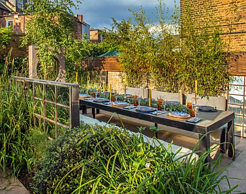 TANYA_SOUTHWORTH_GARDEN_LONDON_DESIGNER_ANOUSHKA_FEILER_TABLE_BENCHES_CANDLES_BAMBOOS_IN_CONTAINERS_