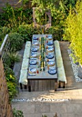 TANYA SOUTHWORTH GARDEN, LONDON, DESIGNER ANOUSHKA FEILER: VIEW ONTO TABLE, BENCHES, CANDLES, BAMBOOS IN CONTAINERS, MIRRORS, SMALL, FORMAL, TOWN, URBAN, ENTERTAINING