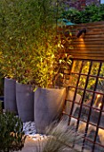 TANYA SOUTHWORTH GARDEN, LONDON, DESIGNER ANOUSHKA FEILER: ANTIQUE MIRROR, CONTAINERS WITH BAMBOO, SMALL, FORMAL, TOWN, URBAN, NIGHT, LIGHTS