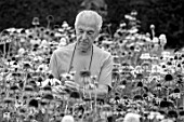 MEADOW FARM GARDEN AND NURSERY, WORCESTERSHIRE: BLACK AND WHITE IMAGE OF ROB COLE AMONGST ECHINACEAS IN THE NURSERY. PERENNIALS, FLOWERS, FLOWERING, LATE, SUMMER
