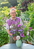 CLAUS DALBY GARDEN, DENMARK: CLAUS DALBY ARRANGING A BOUQUET OF FLOWERS FROM THE GARDEN