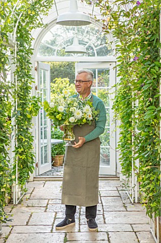 CLAUS_DALBY_GARDEN_DENMARK_CLAUS_DALBY_IN_HIS_GREENHOUSE_HOLDING__A_BOUQUET_OF_WHITE_FLOWERS_FROM_TH