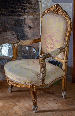 PYTTS_HOUSE_OXFORDSHIRE_THE_DINING_ROOM_VINTAGE_GILT_AND_PINK_DAMASK_CHAIR_BY_FIREPLACE