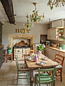 PYTTS HOUSE, OXFORDSHIRE: KITCHEN WITH GREEN CHAIRS, WOODEN TABLE, AGA