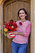 ALHAM FARM, SOMERSET: CORNISHWARE: KARINA RICKARDS HOLDING FLOWERS AT HER FRONT DOOR