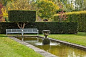 RADCOT HOUSE, OXFORDSHIRE: THE LONG POND. POOL, RILL, WATER, YEW HEDGES, HEDGING, WHITE, METAL, SEATING, BENCH, CLIPPED, TOPIARY