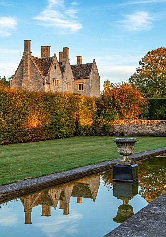 RADCOT_HOUSE_OXFORDSHIRE_THE_HOUSE_SEEN_FROM_THE_LONG_POND_BEECH_HEDGES_HEDGING_POOL_CANAL_AUTUMN_RE