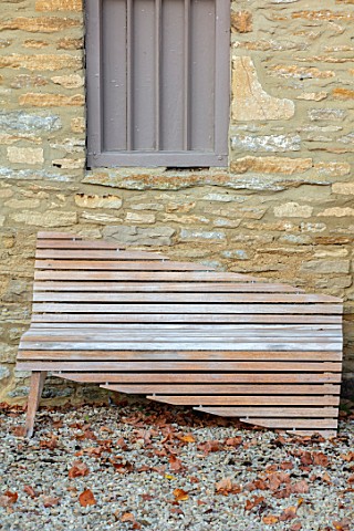 RADCOT_HOUSE_OXFORDSHIRE_UNUSUAL_WOODEN_SEAT_BY_WALL_IN_THE_COURTYARD