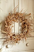 FLOWERS FROM THE FARM, MARBURY HALL, DESIGNER SOFIE PATON-SMITH: DRIED SEED HEAD WREATH ON CUPBOARD DOOR. NIGELLA, PENNY CRESS, POPPY HEADS, NATURAL, WREATHS