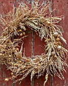 FLOWERS FROM THE FARM, MARBURY HALL, DESIGNER SOFIE PATON-SMITH: DRIED SEED HEAD WREATH ON SHED DOOR. NIGELLA, PENNY CRESS, POPPY HEADS, NATURAL, WREATHS