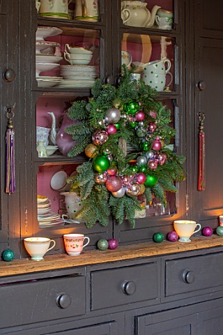 PYTTS_HOUSE_OXFORDSHIRE_KITCHEN_CHRISTMAS_CABINET_WITH_WREATH_CUPS_AND_SAUCERS_COUNTRY_CLASSIC