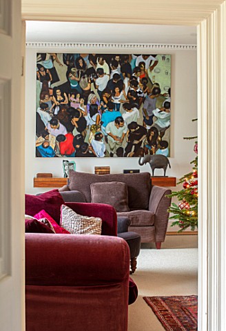 GIBBONS_CROFT_WEST_CLANDON_SURREY_CHRISTMAS__SITTING_ROOM_RED_SOFAS_PAINTING_BY_FAMILY_FRIEND